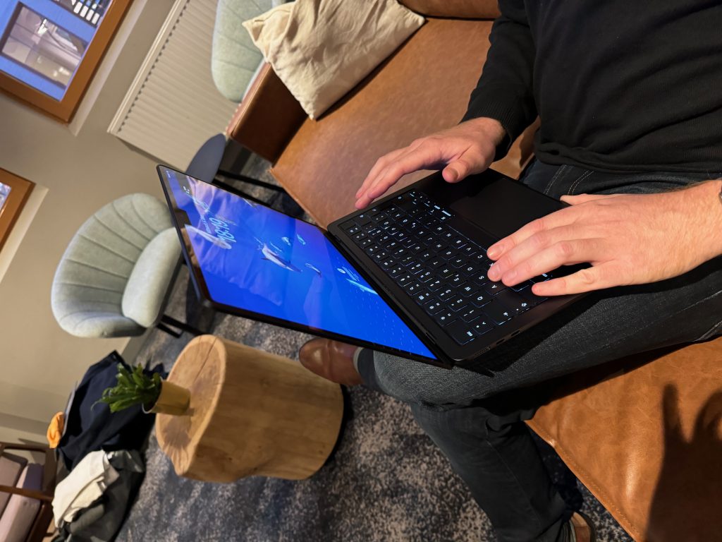 Man sieht hier eine Lounge und die Hände einer Person, die auf einem Sofa sitzt. Die Hände liegen auf der Tastatur eines Laptops, der leicht gedreht ist.
Um die Ecke denken – wenn du erfolgreich mit KI arbeiten möchtest, musst du zuerst deine Perspektive ändern.