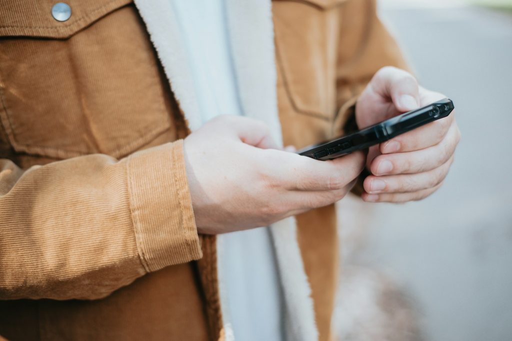 Jemand hält sein Smartphone in der Hand und drückt die Tasten. Die Zukunft der Kreativität und der Expertenarbeit liegt nicht darin, mit der KI in der Datenanalyse zu konkurrieren. Darin ist sie jetzt schon besser als die meisten von uns. Sie liegt darin, diese zutiefst menschlichen Fähigkeiten zu kultivieren und sie mit der analytischen Kraft der KI zu kombinieren. Ich wiederhole es, so oft es notwendig ist: Mensch und KI zusammen sind eine Superkraft. Oder, was meinst du?