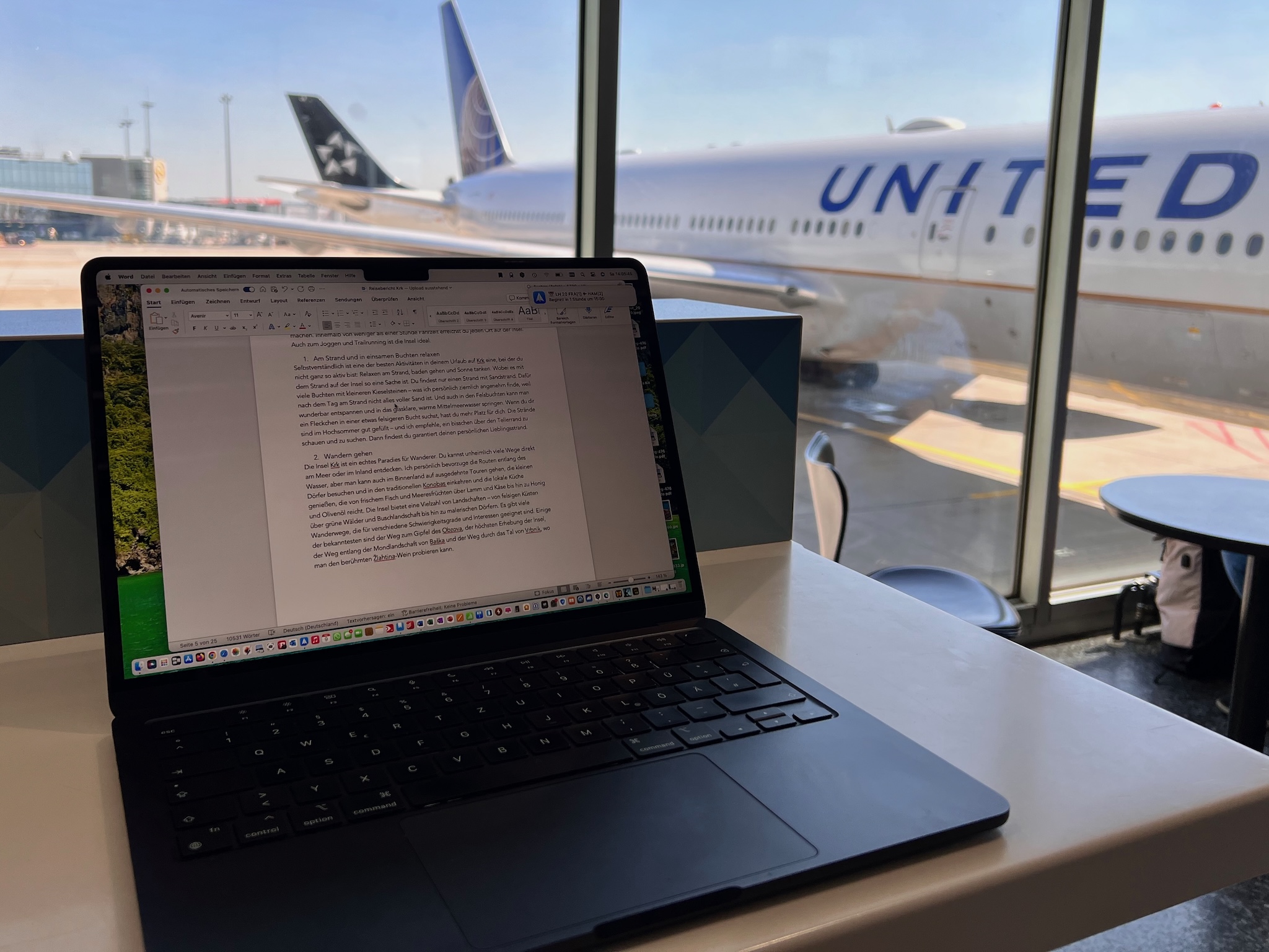 MacBook an einem Flughafen während der mobilen redaktionellen Arbeit