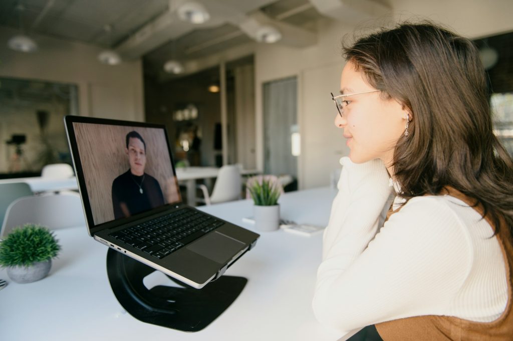 Eine Frau sitzt vor einem Laptop und hat einen einzigen Gegenüber auf dem Computer in einem Videoanruf.
Videocalls von Angesicht zu Angesicht, also mit einem Gegenüber, werden als wesentlich angenehmer wahrgenommen, denn solche in größeren Gruppen. Je größer die Gruppe, desto unangenehmer die Videokonferenz.