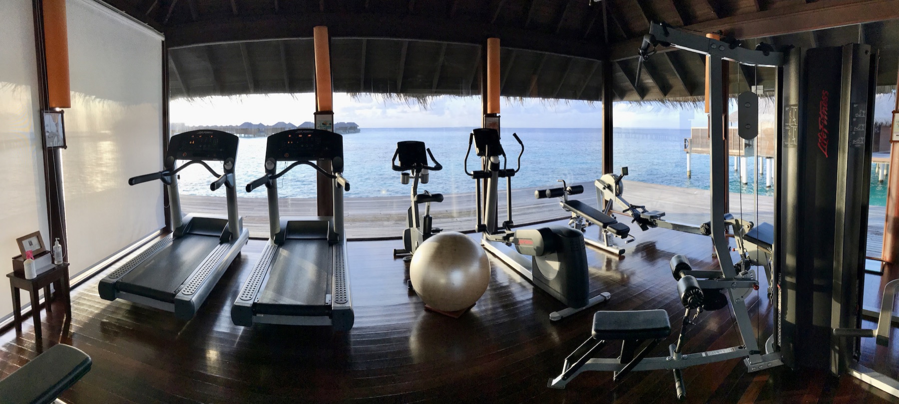 Fitnessraum mit Laufbändern und Trainingsgeräten vor dem Meer