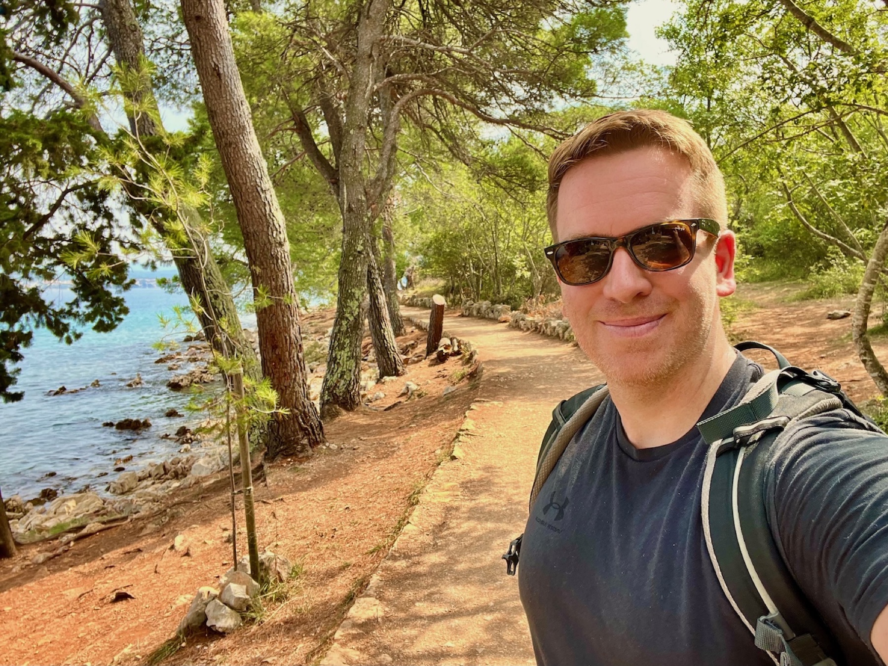 Sascha Tegtmeyer beim Wandern auf einem bewaldeten Küstenweg der Insel Krk
