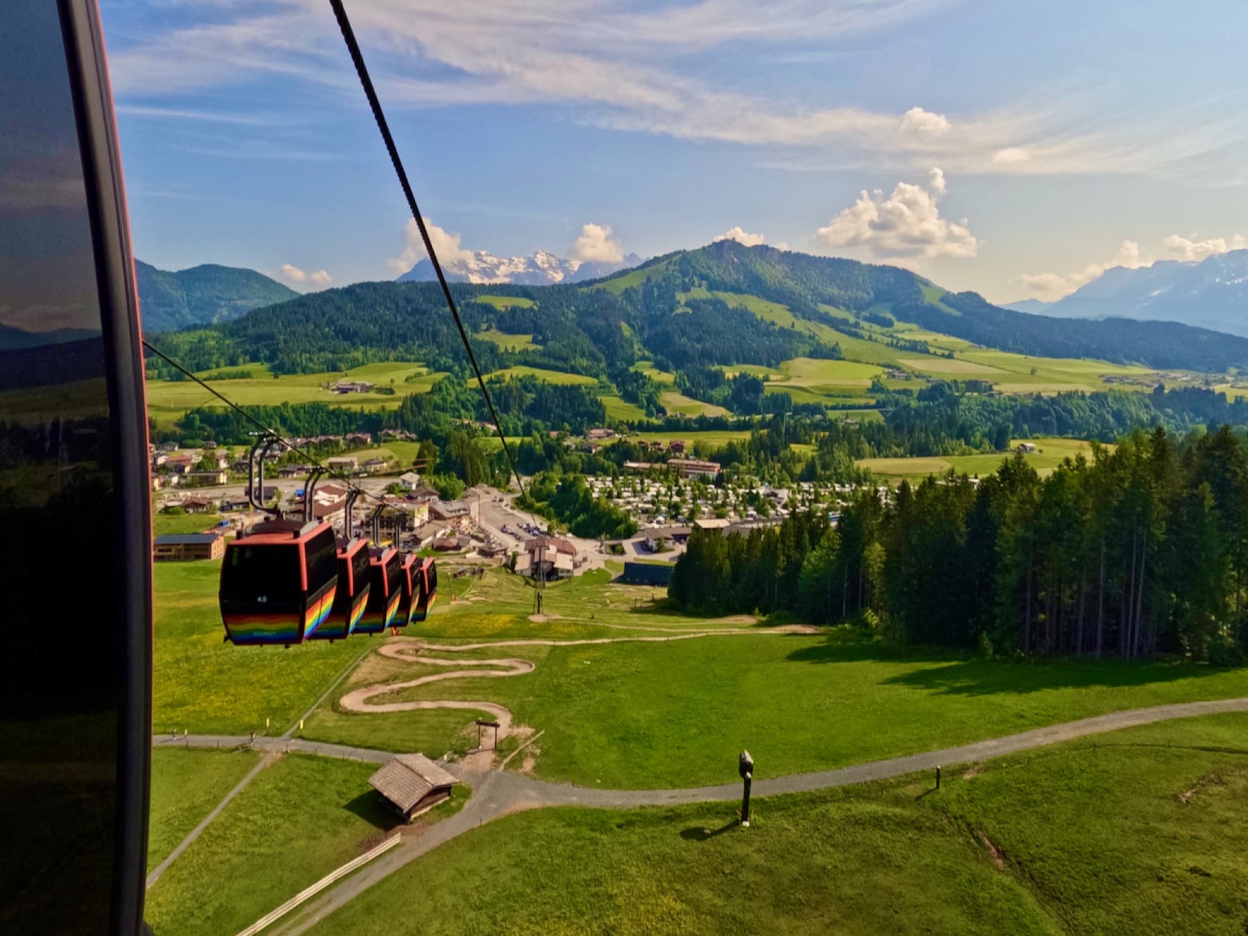 Bergbahn über grünen Hängen und dem Ort Fieberbrunn