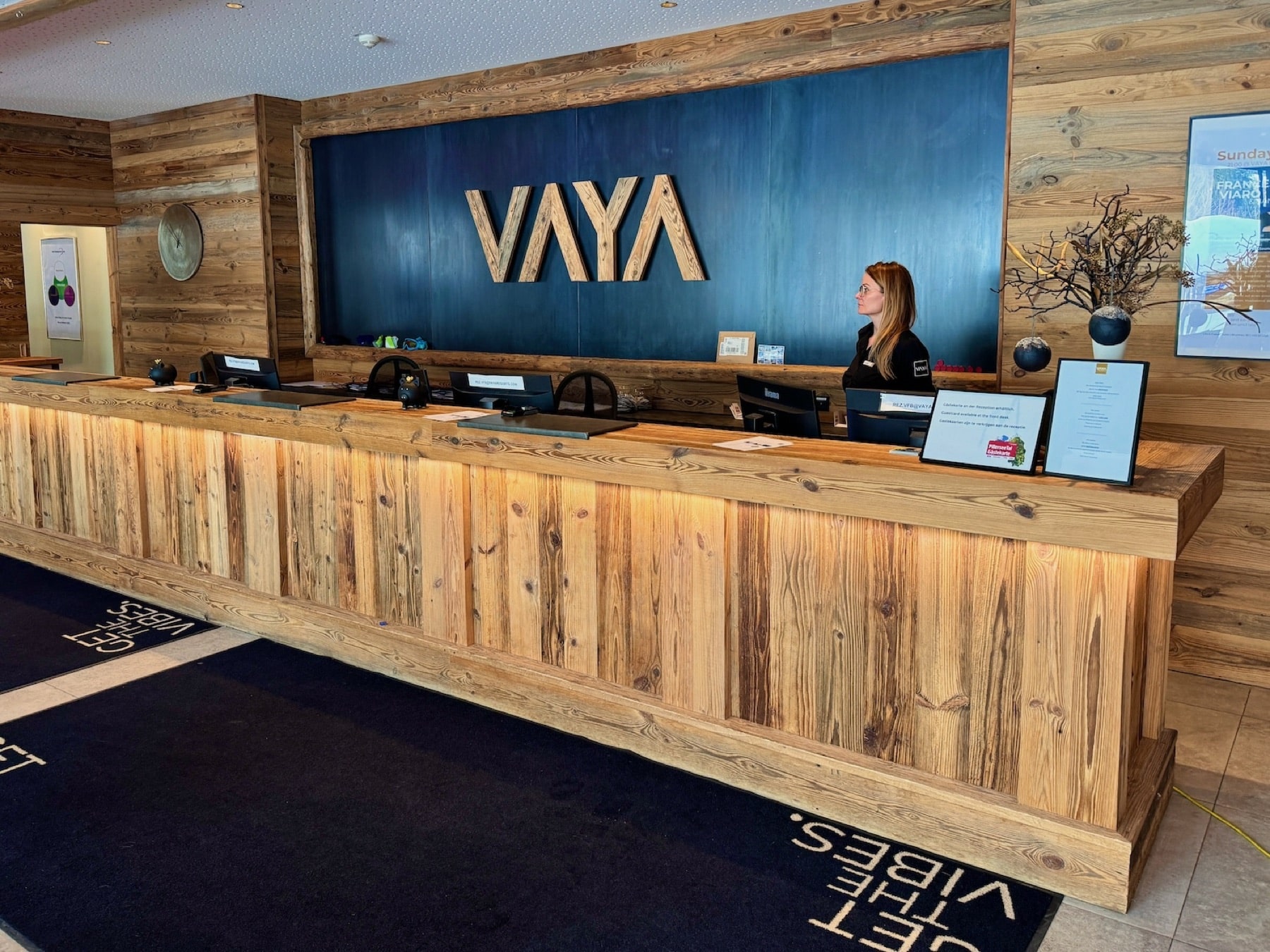 Holzverkleidete Hotelrezeption des VAYA Fieberbrunn